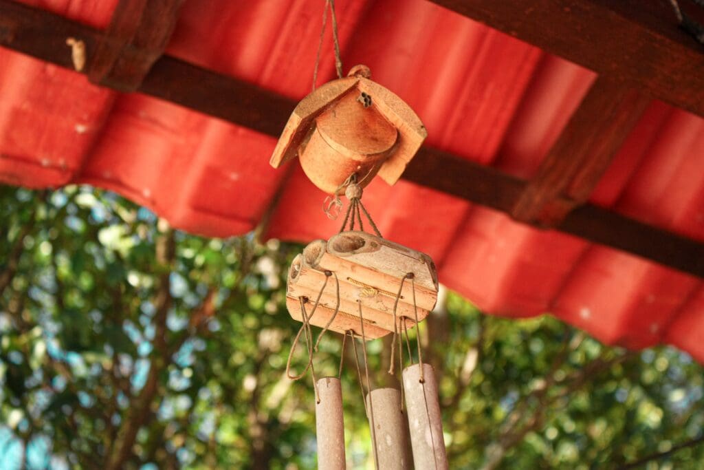 bamboo windchimes hanging suspended under red roof
